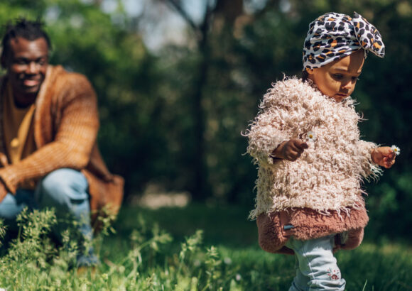 A parent looks at his daughter from a slight distance as they explore the outdoors. | Image: Imani Montessori School