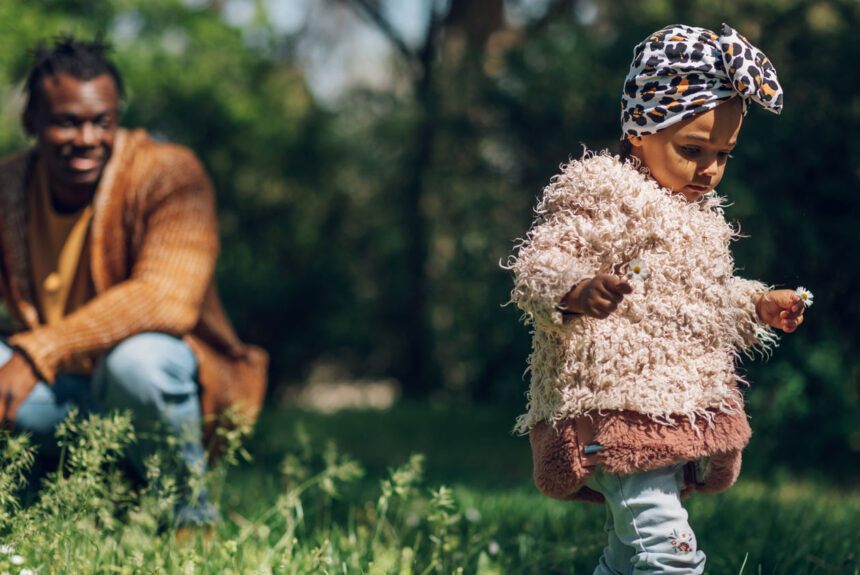 A parent looks at his daughter from a slight distance as they explore the outdoors. | Image: Imani Montessori School